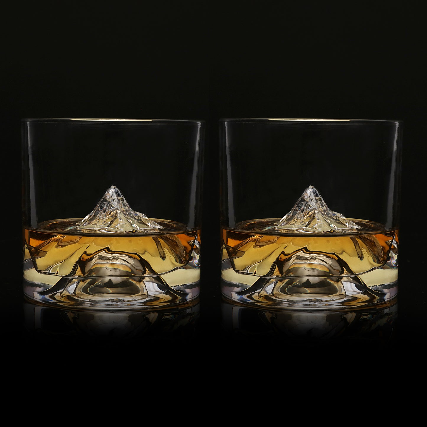 Two K2 crystal whiskey glasses filled with whiskey, showcasing mountain-inspired interior and ultra-clear glass.